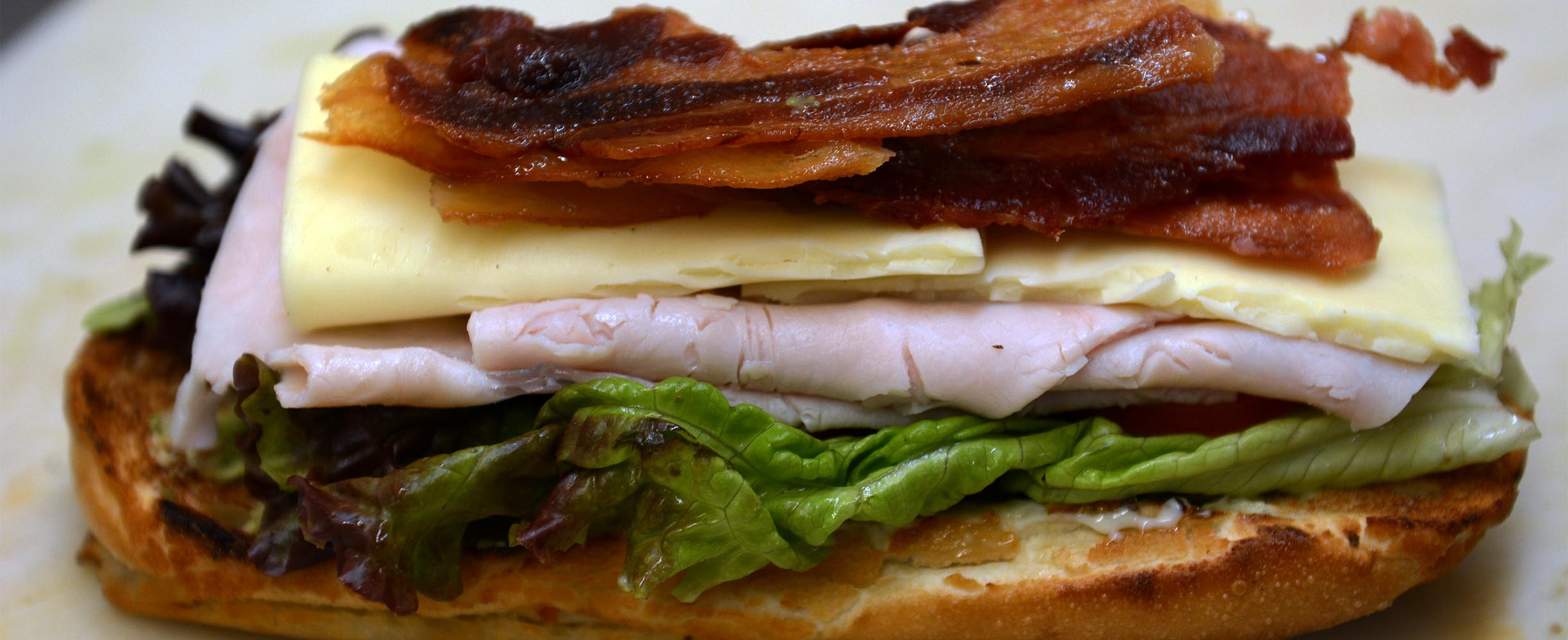 A sandwich with bacon, cheese, turkey, lettuce and tomato plus mayonnaise and spices is just fantastic!